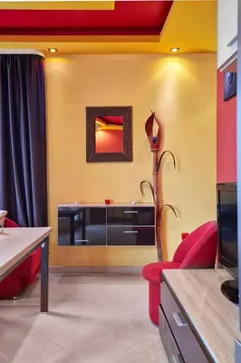 a living room with a red couch and a tv at The Love Nest - 1BD Apartment in Sunny Beach by Flat Mаnаger in Sunny Beach