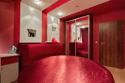 a red bedroom with a red bed and a mirror at The Love Nest - 1BD Apartment in Sunny Beach by Flat Mаnаger in Sunny Beach