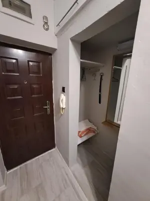 a hallway with a brown door and a bedroom at Studio Demokratsia in Burgas City