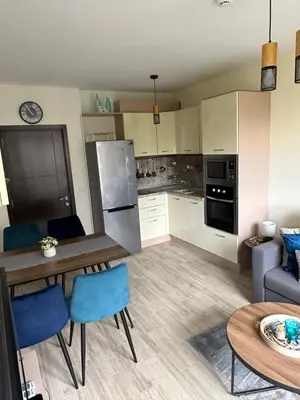 a kitchen and living room with a table and chairs at Apartament CASCADAS FAMILY in Sunny Beach