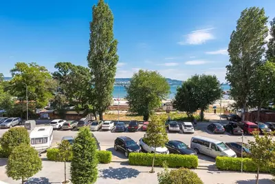 a parking lot with parked cars and trees at Casa de la playa in Varna City