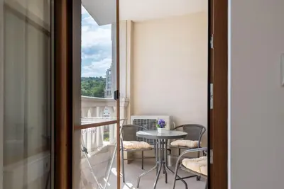 a balcony with a table and chairs and a window at Casa de la playa in Varna City