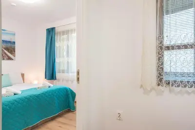 a bedroom with a blue bed and a window at Peaceful Central Place - Vazov street in Varna City