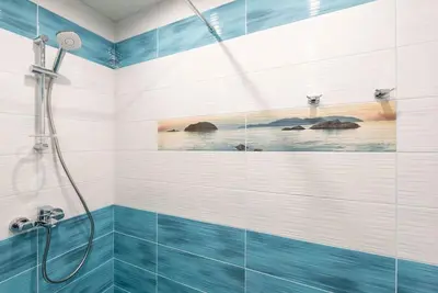 a bathroom with a shower with blue and white tiles at Peaceful Central Place - Vazov street in Varna City