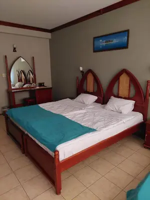 a bedroom with a large bed with a wooden frame at Hotel Niko's in Pomorie