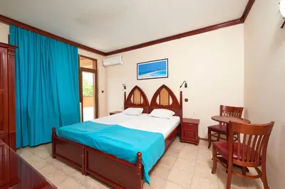 a bedroom with a bed and a table and chairs at Hotel Niko's in Pomorie