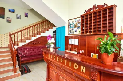 a lobby with a reception desk and a staircase at Hotel Niko's in Pomorie