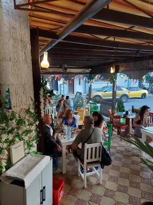 a group of people sitting at tables in a restaurant at Hotel Niko's in Pomorie