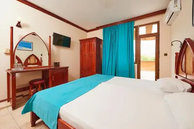 a bedroom with a bed and a vanity and a mirror at Hotel Niko's in Pomorie