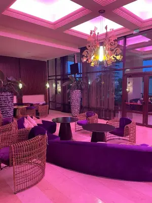 a lobby with tables and chairs and a chandelier at Royal Beach NICE VIEW in Sunny Beach