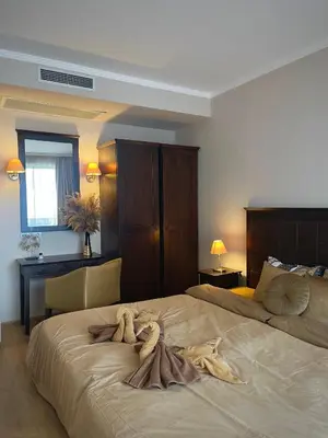 a bedroom with a large bed with a robe on it at Royal Beach NICE VIEW in Sunny Beach