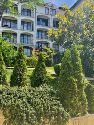a building with trees and bushes in front of it at Apartment Marina beach k-s Triumph in Sveti Vlas