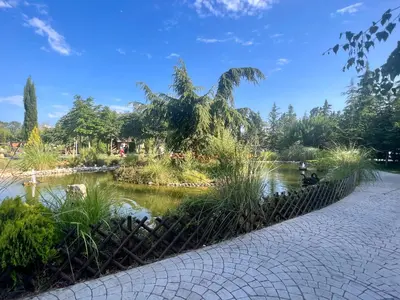 a pond in a park next to a walkway at Deluxe Appartements in Cascadas Family Resort Sunny Beach in Sunny Beach