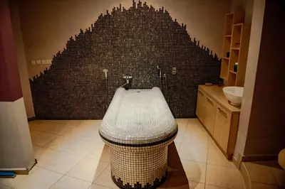 a bathroom with a black tile wall and a tub at Sea View Apartments - Aheloy in Ravda