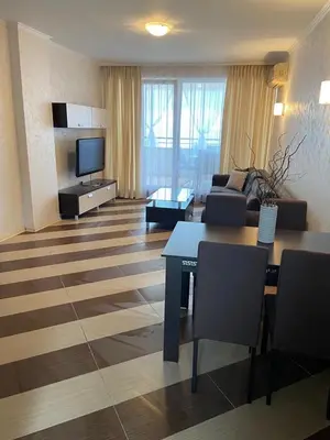 a living room with a couch and a tv at SEAVIEW Heaven Sunny Beach in Sunny Beach