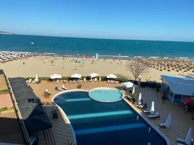 a view of a beach with a swimming pool and umbrellas at SEAVIEW Heaven Sunny Beach in Sunny Beach
