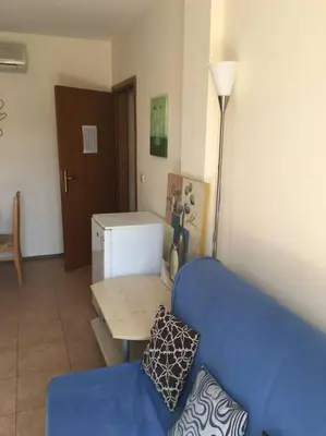 a living room with a blue couch and a table at 3 Bedroom Apt with Pool Views at Arcadia Complex in Sunny Beach