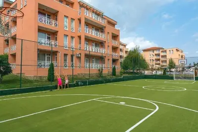 a tennis court in front of a building at Ground Floor, Studio Apartment at Sunny Day 6 in Tŭnkovo