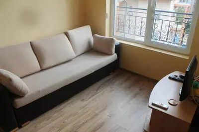 a couch sitting in a room with a window at Spacious, 1 Bed Apt, Dawn Park in Sunny Beach