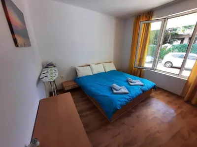 a bedroom with a bed with blue sheets and a window at Central, 1 Bed Apt, 3* Yassen in Sunny Beach