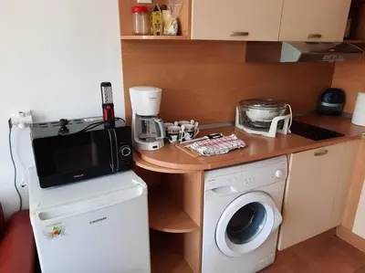 a small kitchen with a washing machine and a microwave at Central, 1 Bed Apt, 3* Yassen in Sunny Beach
