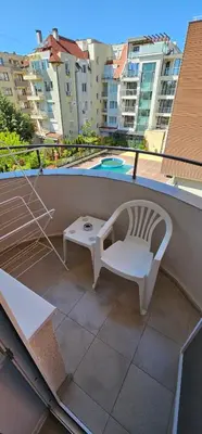 a white chair and a table on a balcony at Studio Nina in Primorsko