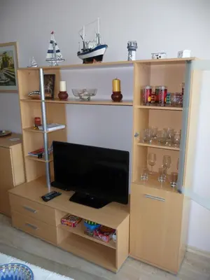 a tv in a wooden book shelf at Great Choice Apartment in Chernomorets