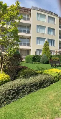 a building with a park with a bench in front of it at Great Choice Apartment in Chernomorets