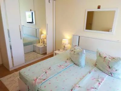a bedroom with a bed and a large mirror at Прекрасный апартамент с видом на море и бассейном in Byala