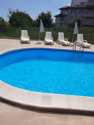 a swimming pool with lounge chairs at Прекрасный апартамент с видом на море и бассейном in Byala