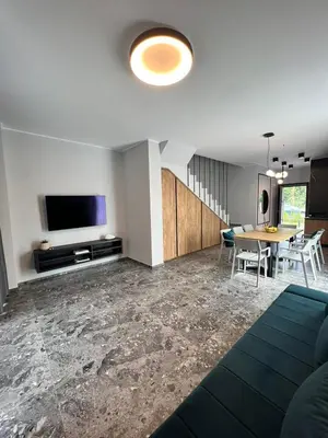a living room with a table and a tv at Villas Park Lozenets in Lozenets