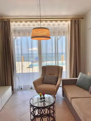 a living room with a couch and a chair and a glass table at SH Holidays & Health Beach-Apartments in Sozopol