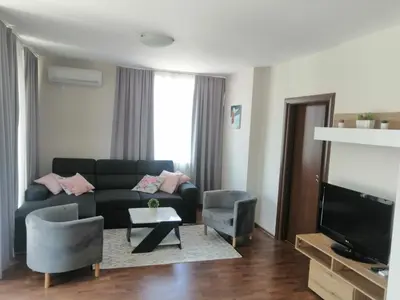a living room with a couch and a tv at Апартамент Sunny home in Chernomorets
