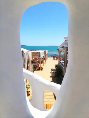 a view of the beach through a hole in a white building at Апартамент Sunny home in Chernomorets