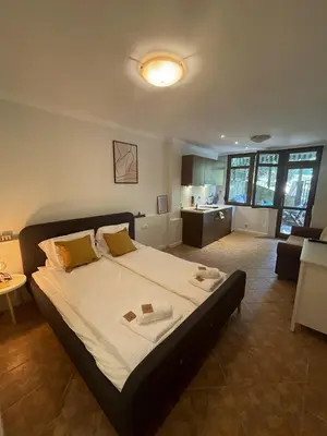 a bedroom with a large bed and a living room at Santa Marina Holiday Village Studio Iskra in Sozopol