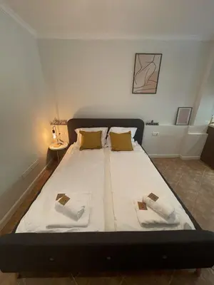 a bed with two pillows on it in a room at Santa Marina Holiday Village Studio Iskra in Sozopol