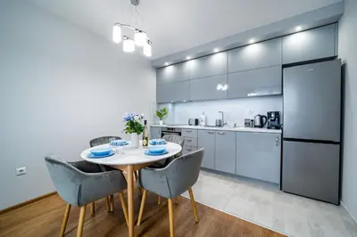 a kitchen and dining room with a table and chairs at Brand New Downtown Apartment in Varna City