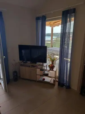 a living room with a flat screen tv and a window at The View Apartment in Sozopol