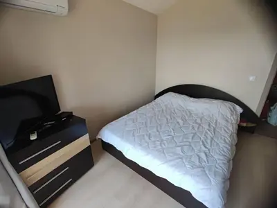 a small bedroom with a bed and a dresser at The View Apartment in Sozopol