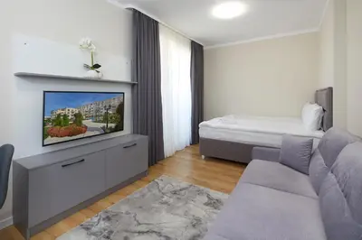 a living room with a tv and a bed at Bellicity Apart Complex in Ravda