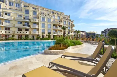 a hotel with a swimming pool in front of a building at Bellicity Apart Complex in Ravda
