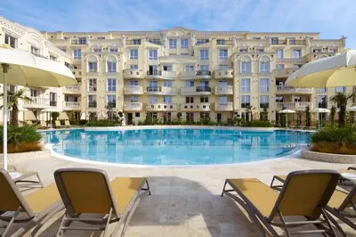 a swimming pool in front of a large building at Bellicity Apart Complex in Ravda