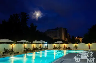 a swimming pool at night with the moon in the sky at Cantilena Complex in Sunny Beach