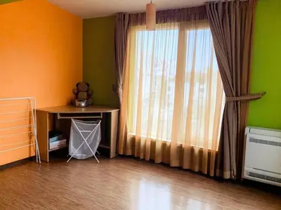 a room with a window with a bed and a table at Aпартамент в близост до морето и центъра in Burgas City