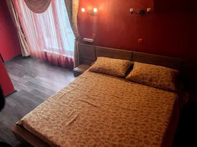 a large bed in a bedroom with red walls at Aпартамент в близост до морето и центъра in Burgas City