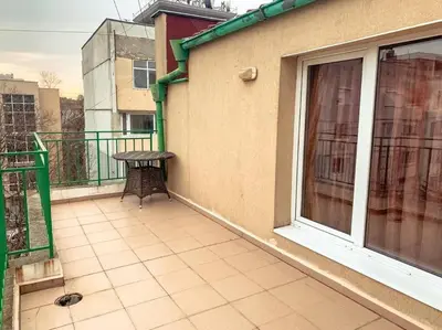 a balcony with a table next to a building at Aпартамент в близост до морето и центъра in Burgas City