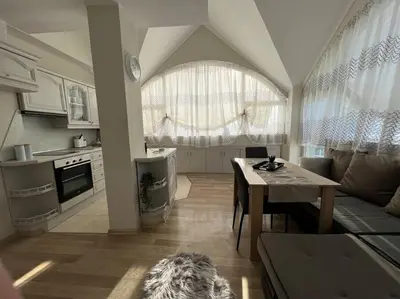 a kitchen and living room with a table and a couch at Център Варна апартамент с паркинг за нормална до средно голяма кола in Varna City