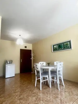 a dining room with a white table and chairs at Elit 4 Apartments in Sunny Beach