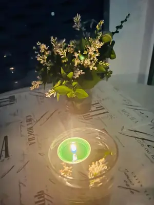 a candle and a vase with flowers on a table at Elit 4 Apartments in Sunny Beach