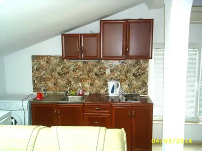 a kitchen with wooden cabinets and a sink at Apartments Bravo 1-Vichevi in Sunny Beach